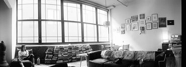Person sitting alone in a spacious, artistic living room.
