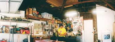 Person working in a cluttered workshop.