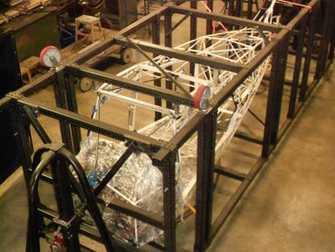 A mechanical testing rig with a metal framework and a structure inside.