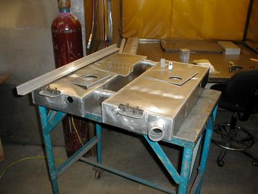 Metal fabrication parts on a worktable in a workshop.