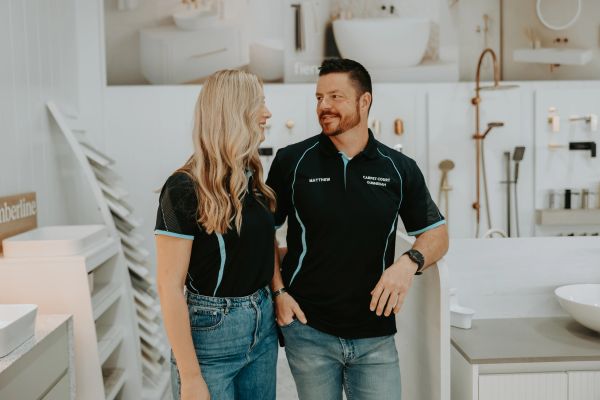 Two people smiling and talking in a showroom.
