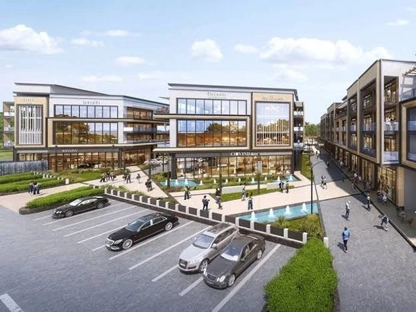 Modern commercial complex with parking and pedestrians.