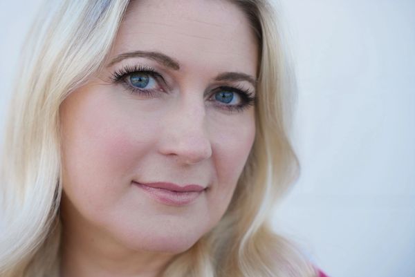 Close-up portrait of a woman with blue eyes and blonde hair.