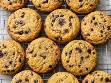 Fresh chocolate chip cookies on a cooling rack.