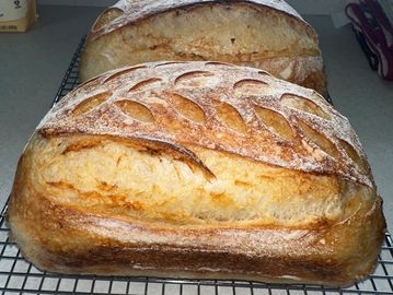 Two freshly baked loaves of bread with decorative scoring.