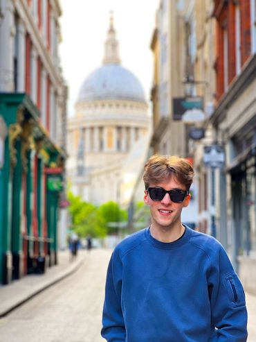 Jamie Moreland wearing a blue jumper and sunglasses with St Paul's Cathedral in the background