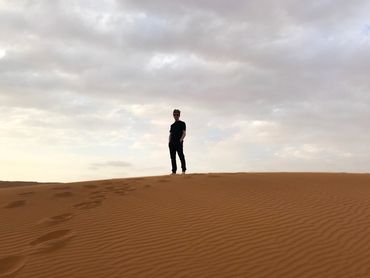 Jamie Moreland stood on a sand dune in the Sharjah Desert, UAE