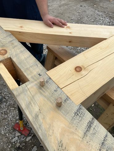Wooden beams being joined with wooden pegs.