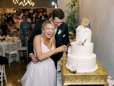 Happy couple cutting wedding cake together.
