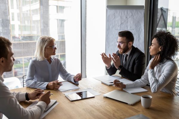 Team meeting with four professionals discussing ideas.