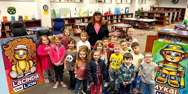Beth Davis with a group of children in a school library