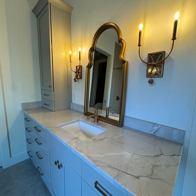 Elegant bathroom vanity with marble countertop and vintage-style mirror.