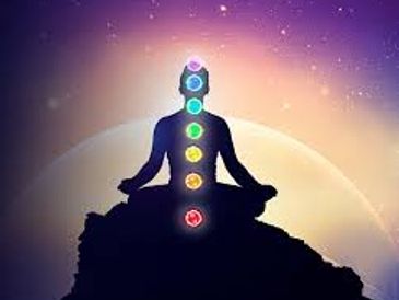 Silhouette meditating with chakras aligned against a cosmic background.