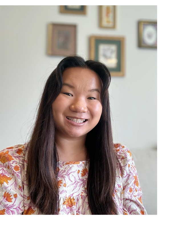 Smiling woman with long dark hair wearing a floral top.