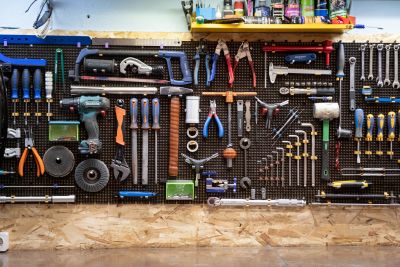 Pegboard wall of hand tools organized above a workbench