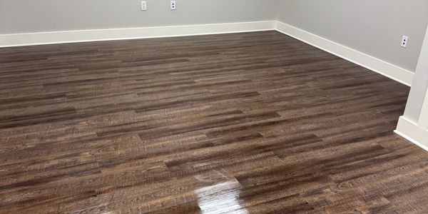 Empty room with polished wood flooring and light gray walls.