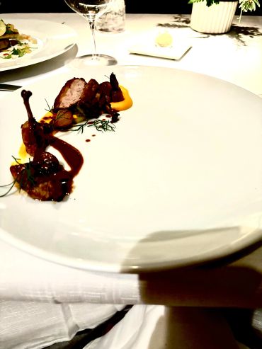 Elegant gourmet meat dish on a white plate.