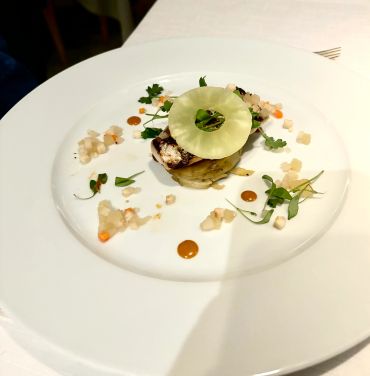 Gourmet dish with artistic plating and fresh garnishes.