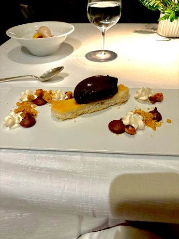 Gourmet dessert with chocolate, cream, and garnishes.