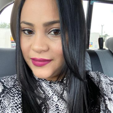 Mujer con cabello lacio y labial rosa oscuro en un vehículo.