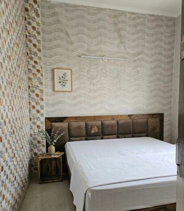 Minimalist bedroom with a wooden headboard and side table.