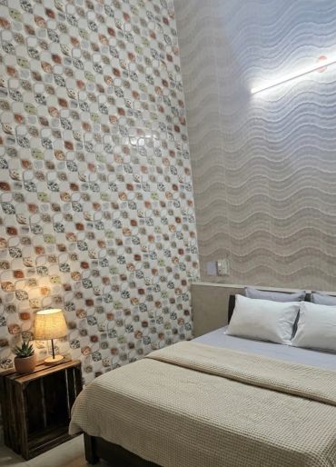 Cozy bedroom with patterned walls and soft lighting.