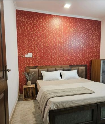 Cozy bedroom with a patterned red accent wall.