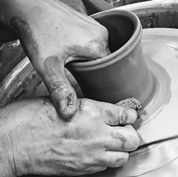 Hands shaping clay on a pottery wheel.
