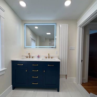 Modern bathroom with double sink vanity in navy and gold accents.