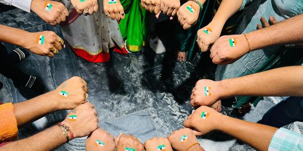 Group showing Indian flag painted fists in a circle.