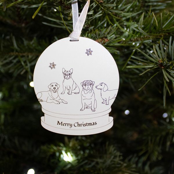 A photo of a dog snow globe hanging on a Christmas tree