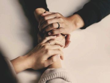 Two people holding hands, symbolizing support and connection.