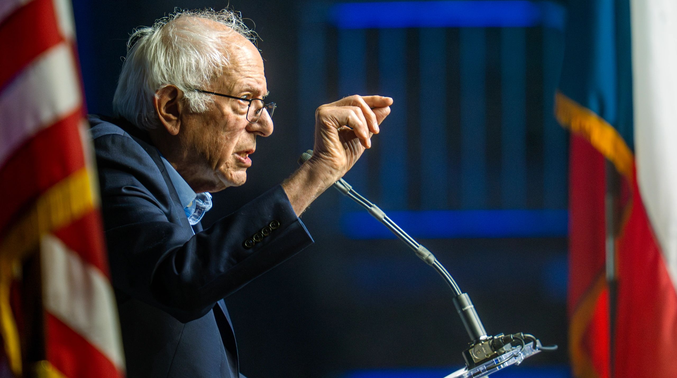 Elderly man speaking passionately at a podium.
