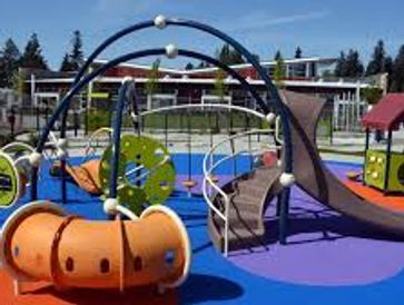 Colorful modern playground with slides and climbing structures under a clear sky.