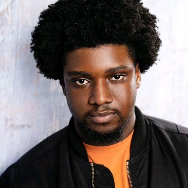 Portrait of a young man with an afro and a serious expression.