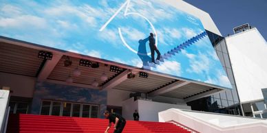 A man preparing a red carpet before an event