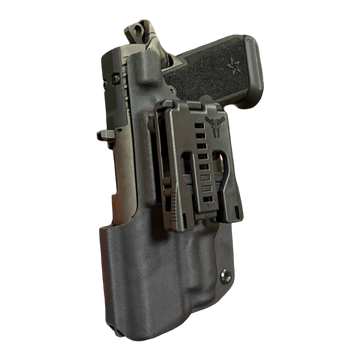 Black handgun in a black holster with a clip attachment.