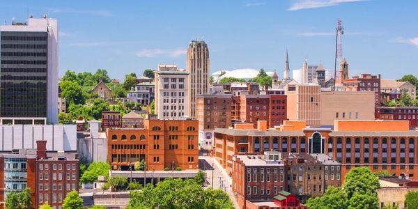 City skyline with mix of modern and historic buildings under a clear blue sky.
