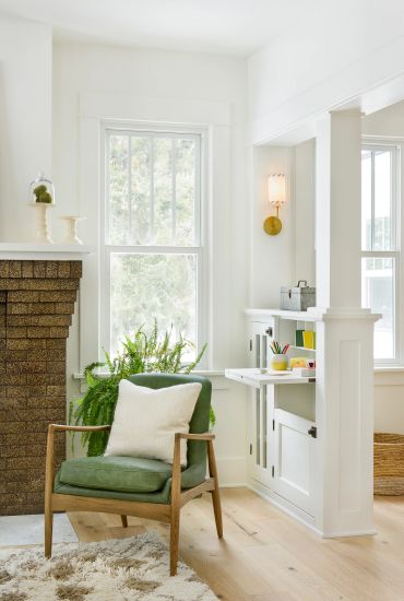 Cozy reading nook with green armchair and natural light.