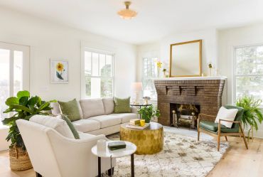 Cozy living room with sofa, chair, and fireplace.