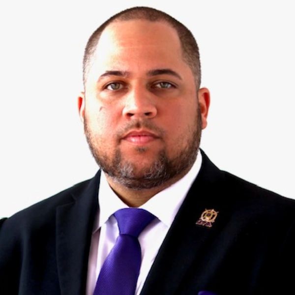 Professional man in a suit and purple tie with serious expression.