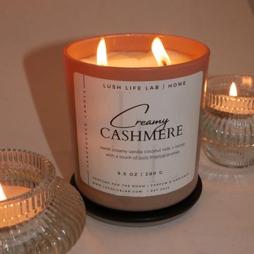 Lit creamy cashmere scented candle with decorative glass holders.