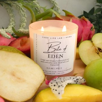 Lit candle surrounded by various fruits.