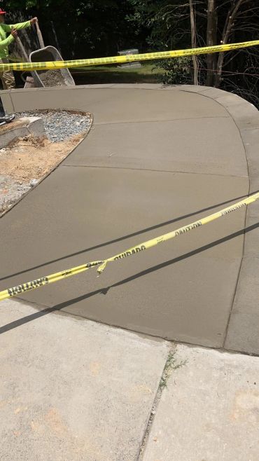 Freshly poured concrete sidewalk with caution tape.