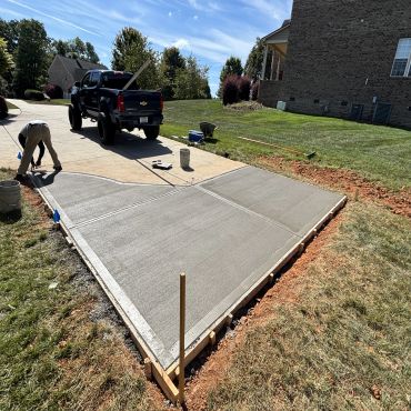 Freshly poured concrete driveway being finished.