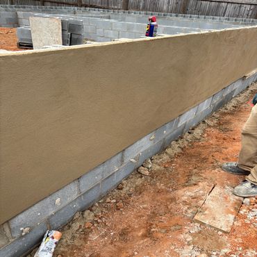 Construction site with a newly plastered wall and cement blocks.