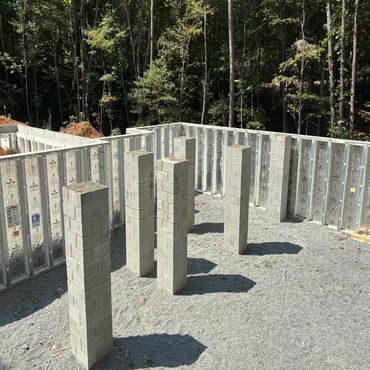Construction site with concrete pillars and insulated walls.