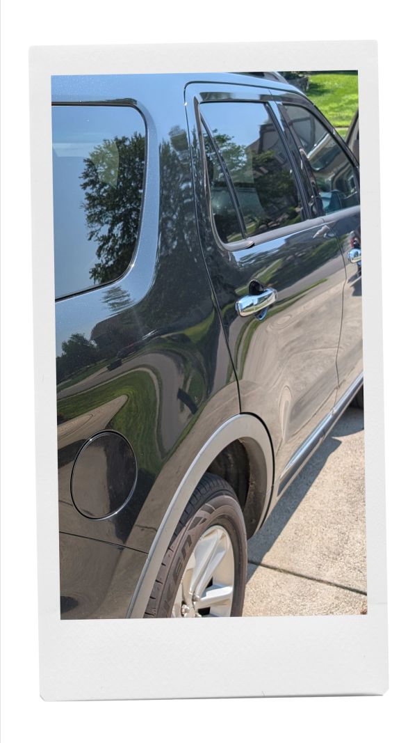 Reflection on a black car door and window.