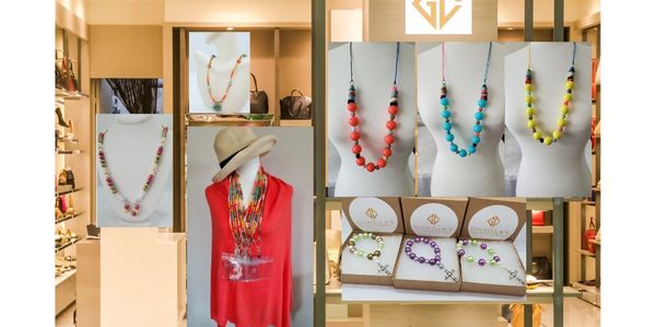 Handmade necklaces and accessories from Gianella’s Creations displayed on stands and a mannequin. Un