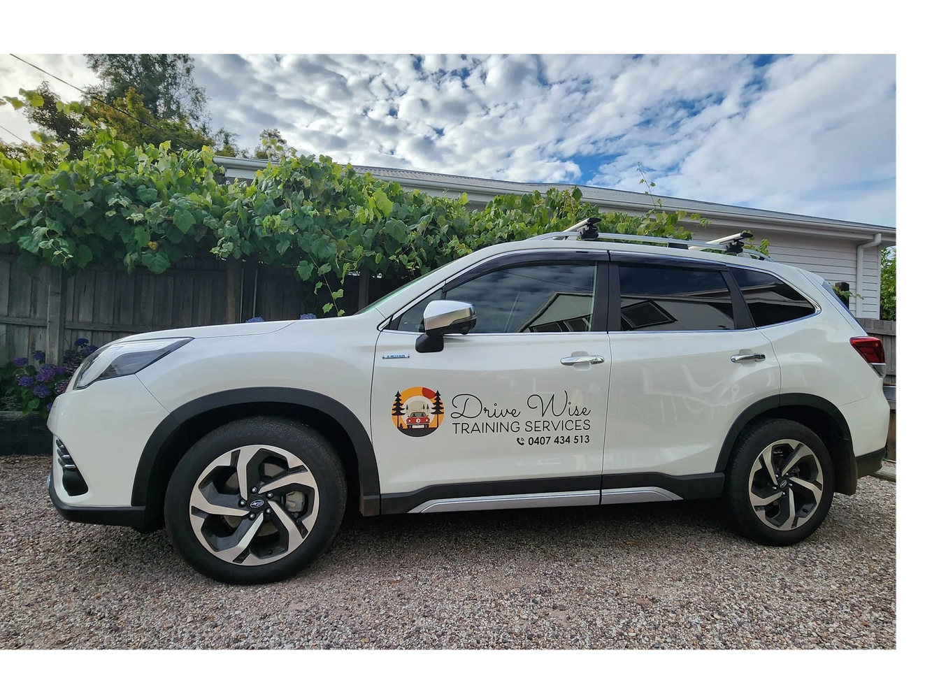 White SUV with Drive Wise Training Services logo parked outside.